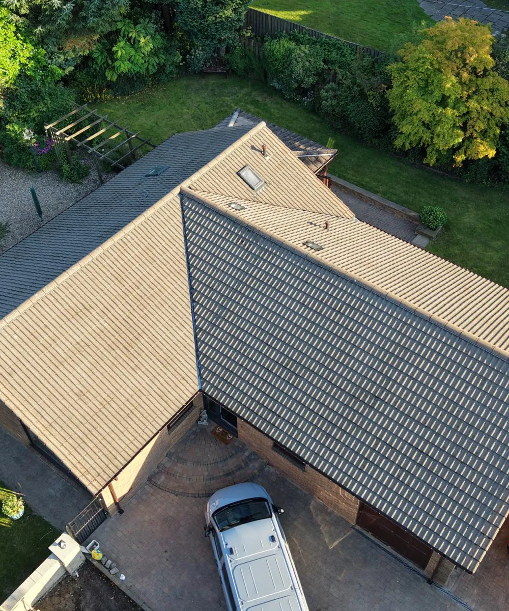 The same bungalow roof from the air after moss removal, tiles clean and light